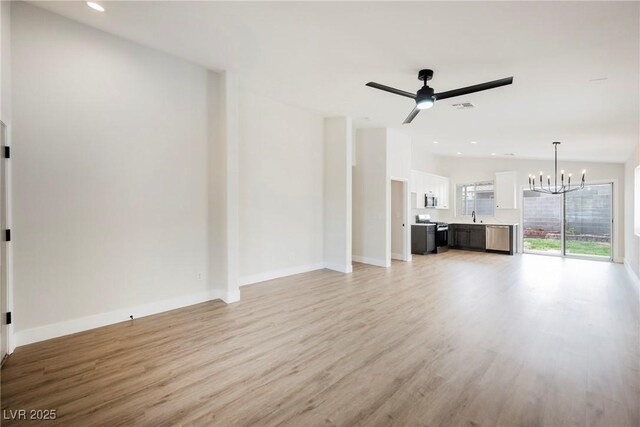 unfurnished living room with recessed lighting, visible vents, light wood finished floors, and ceiling fan with notable chandelier