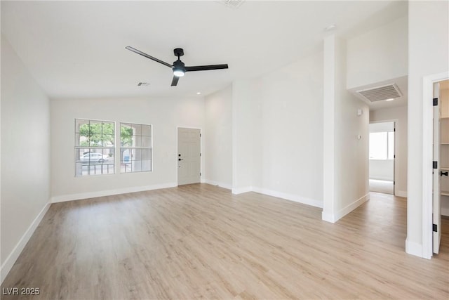 unfurnished living room featuring a healthy amount of sunlight, ceiling fan, vaulted ceiling, and light wood finished floors