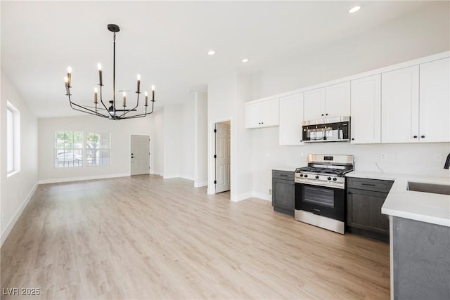 kitchen featuring light countertops, a chandelier, light wood-style flooring, stainless steel appliances, and recessed lighting