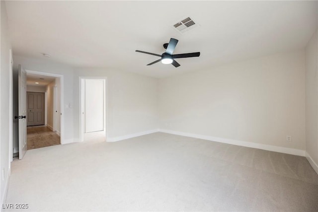 spare room featuring light colored carpet, baseboards, visible vents, and a ceiling fan