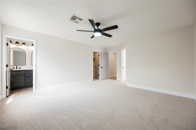 unfurnished bedroom with visible vents, a sink, baseboards, and light carpet