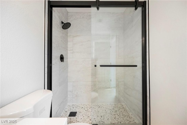 bathroom with a stall shower and toilet