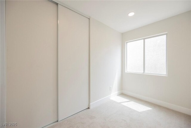 unfurnished bedroom with carpet floors, baseboards, a closet, and recessed lighting