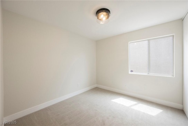 unfurnished room featuring carpet floors and baseboards