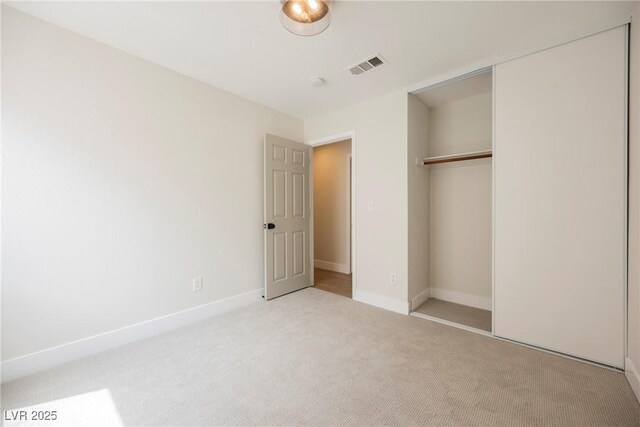unfurnished bedroom featuring carpet flooring, baseboards, visible vents, and a closet