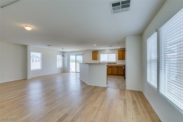 11668 Tierney Creek Dr, Las Vegas, NV 89183 - kitchen with open floor plan, brown cabinets, light wood-style flooring, light countertops, and recessed lighting