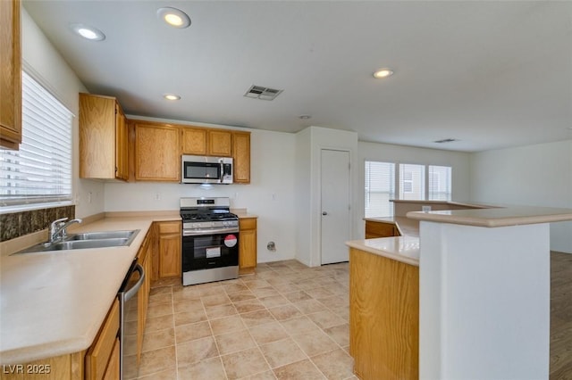 11668 Tierney Creek Dr, Las Vegas, NV 89183 - kitchen with appliances with stainless steel finishes, a sink, light countertops, and recessed lighting