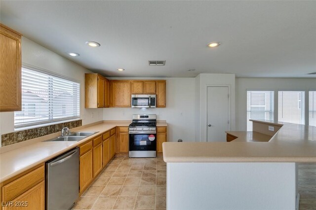 11668 Tierney Creek Dr, Las Vegas, NV 89183 - kitchen featuring appliances with stainless steel finishes, a sink, light countertops, recessed lighting, and light tile patterned flooring