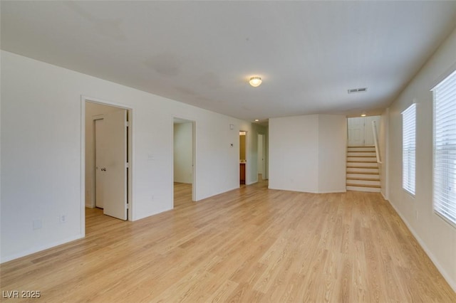 11668 Tierney Creek Dr, Las Vegas, NV 89183 - unfurnished living room with light wood-style flooring and stairs