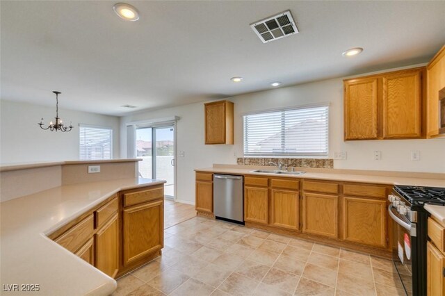11668 Tierney Creek Dr, Las Vegas, NV 89183 - kitchen with appliances with stainless steel finishes, a sink, light countertops, a chandelier, and recessed lighting