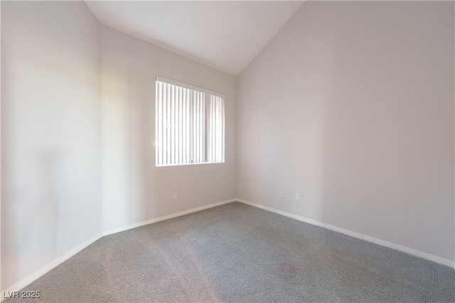 empty room with lofted ceiling, baseboards, and carpet