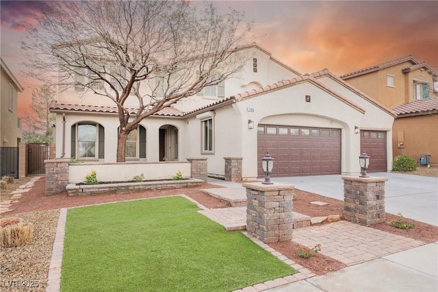 mediterranean / spanish house with stucco siding, a tile roof, an attached garage, and concrete driveway