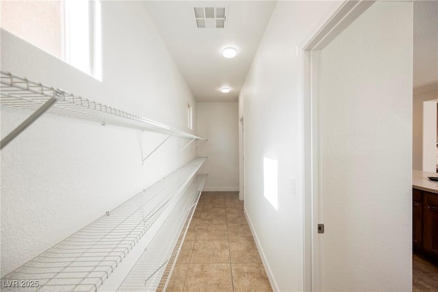 spacious closet featuring visible vents and light tile patterned floors