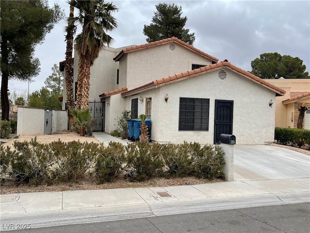 3821 Dream St, Las Vegas, NV 89108 - mediterranean / spanish home with a tiled roof, stucco siding, and a gate