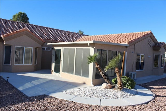 back of property featuring stucco siding, a patio, a tiled roof, and ac unit
