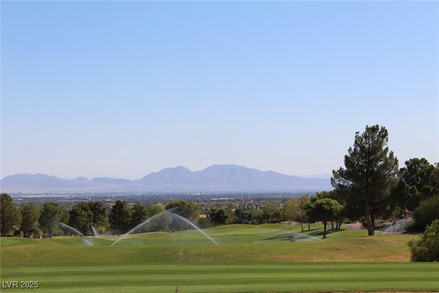 view of property's community featuring a yard, view of golf course, and a mountain view
