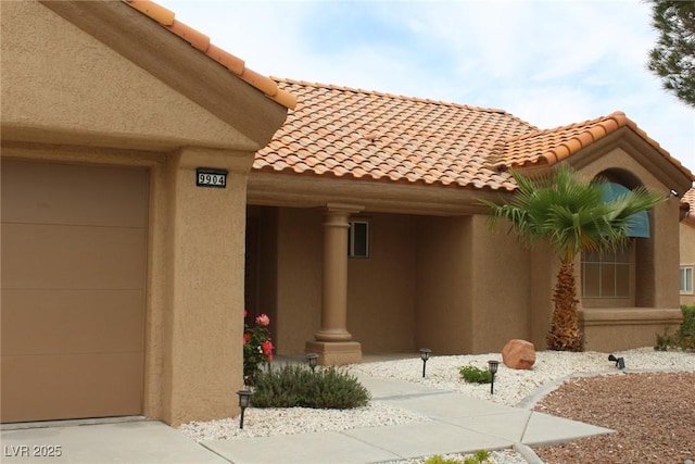 view of exterior entry featuring a tile roof and stucco siding