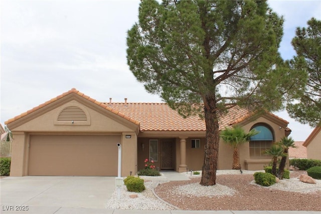 view of front of property featuring an attached garage, a tile roof, stucco siding, and concrete driveway