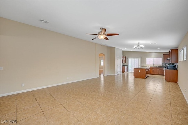 7822 Whitlocks Mill Ave, Las Vegas, NV 89147 - unfurnished living room with a chandelier, ceiling fan, arched walkways, light tile patterned floors, and baseboards