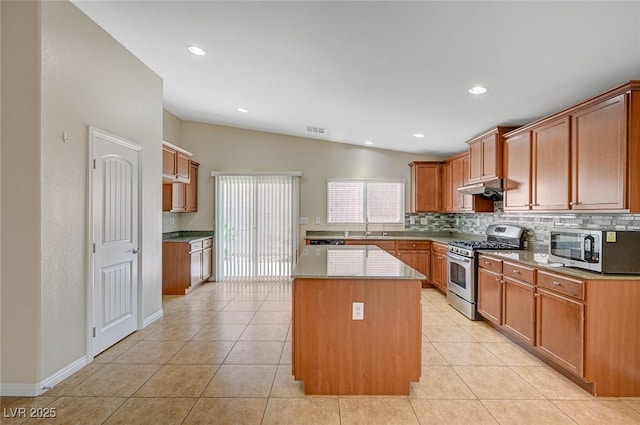 7822 Whitlocks Mill Ave, Las Vegas, NV 89147 - kitchen with stainless steel appliances, tasteful backsplash, a kitchen island, under cabinet range hood, and light tile patterned floors