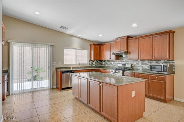 7822 Whitlocks Mill Ave, Las Vegas, NV 89147 - kitchen with appliances with stainless steel finishes, a sink, under cabinet range hood, backsplash, and lofted ceiling