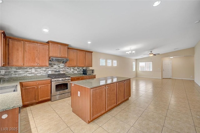 7822 Whitlocks Mill Ave, Las Vegas, NV 89147 - kitchen featuring appliances with stainless steel finishes, tasteful backsplash, light tile patterned floors, a center island, and ceiling fan