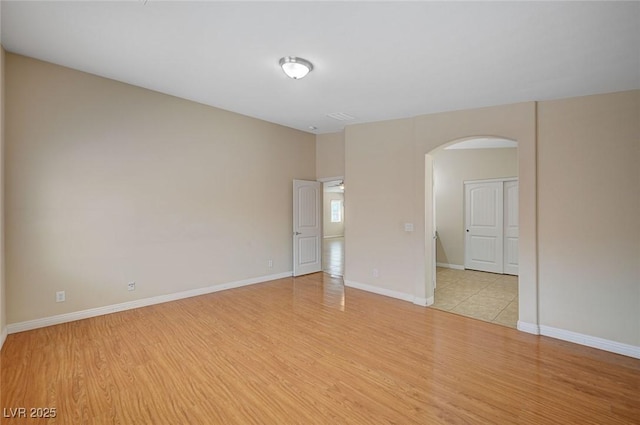 7822 Whitlocks Mill Ave, Las Vegas, NV 89147 - empty room with arched walkways, light wood finished floors, and baseboards