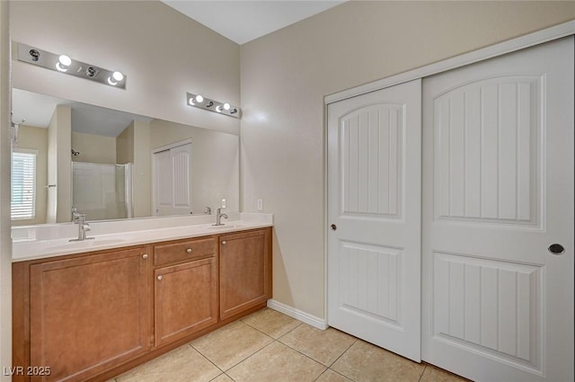 7822 Whitlocks Mill Ave, Las Vegas, NV 89147 - full bathroom with tile patterned flooring, a stall shower, double vanity, and baseboards