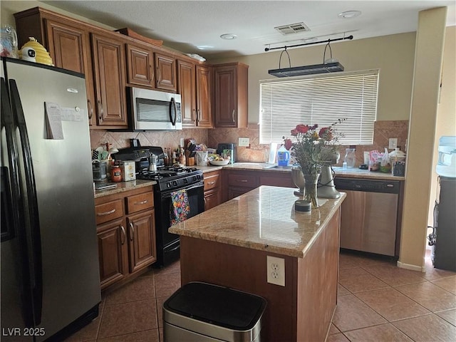 4256 Perfect Drift St, Las Vegas, NV 89129 - kitchen with stainless steel appliances, light tile patterned floors, a kitchen island, and light stone counters
