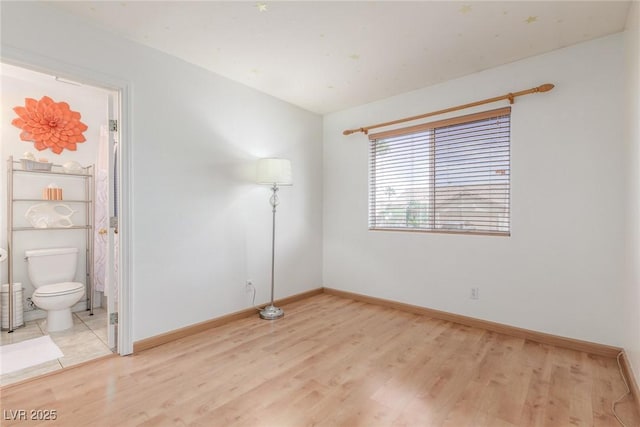 805 Blue Springs Dr, Henderson, NV 89002 - unfurnished bedroom with baseboards, connected bathroom, and light wood-style floors