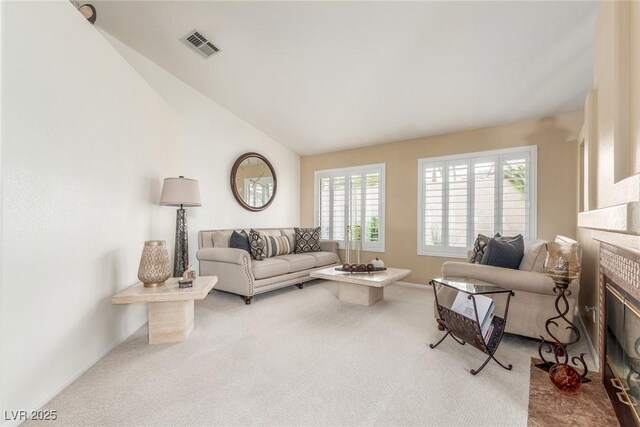805 Blue Springs Dr, Henderson, NV 89002 - carpeted living area with lofted ceiling, baseboards, a glass covered fireplace, and visible vents