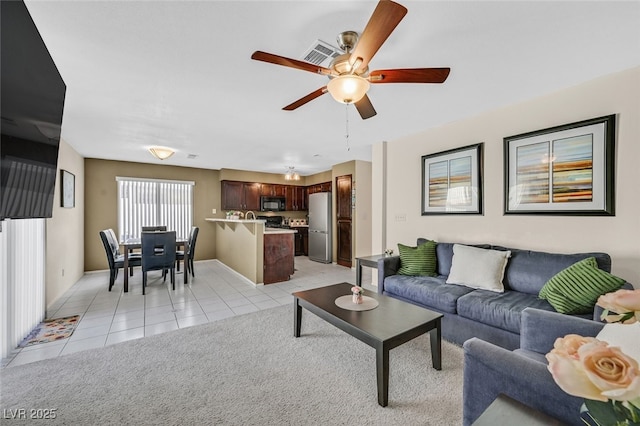 living room featuring visible vents, a ceiling fan, and light tile patterned floors