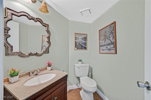 bathroom featuring vanity, toilet, tile patterned flooring, and baseboards