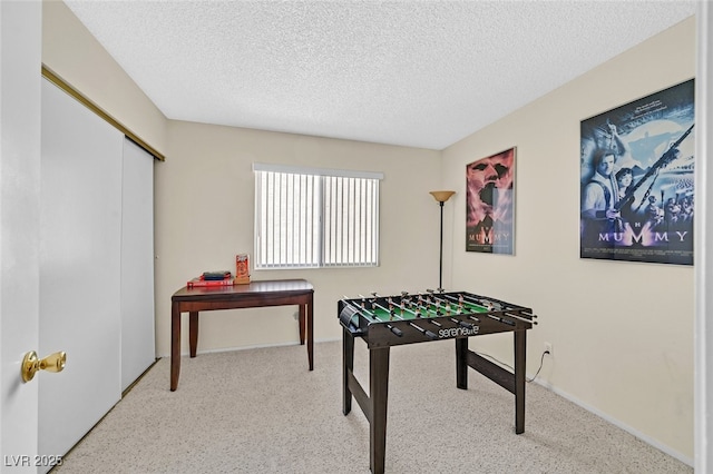 rec room with carpet flooring and a textured ceiling