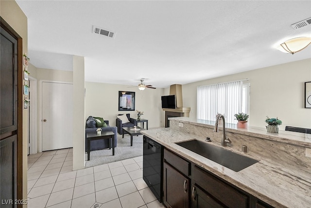 kitchen with light tile patterned floors, visible vents, a sink, and black dishwasher