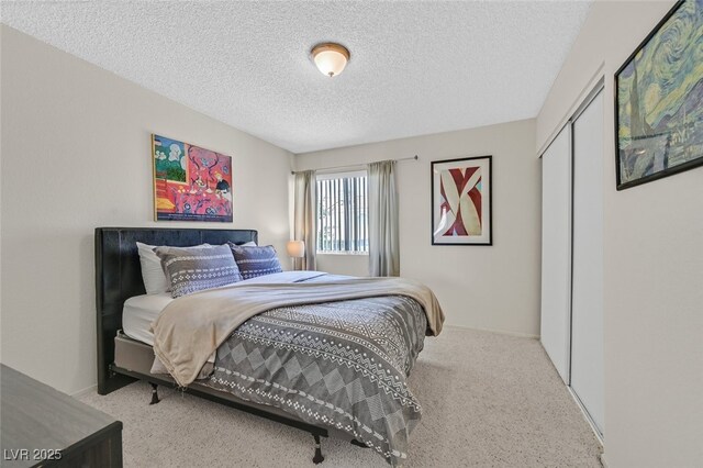 bedroom with carpet flooring, a textured ceiling, and a closet