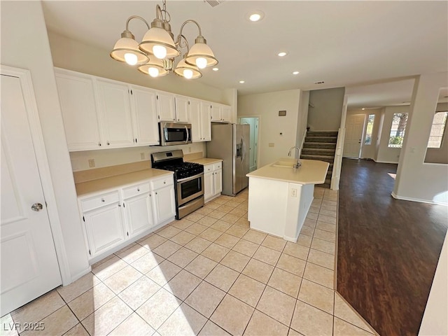 kitchen featuring white cabinets, a sink, recessed lighting, light countertops, and appliances with stainless steel finishes