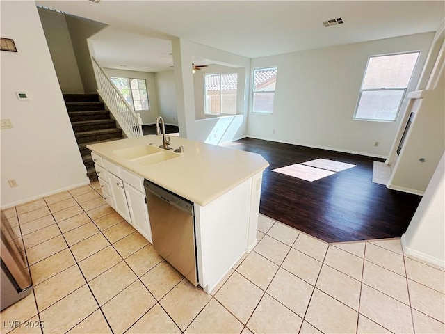 kitchen featuring visible vents, stainless steel dishwasher, a sink, light tile patterned flooring, and open floor plan
