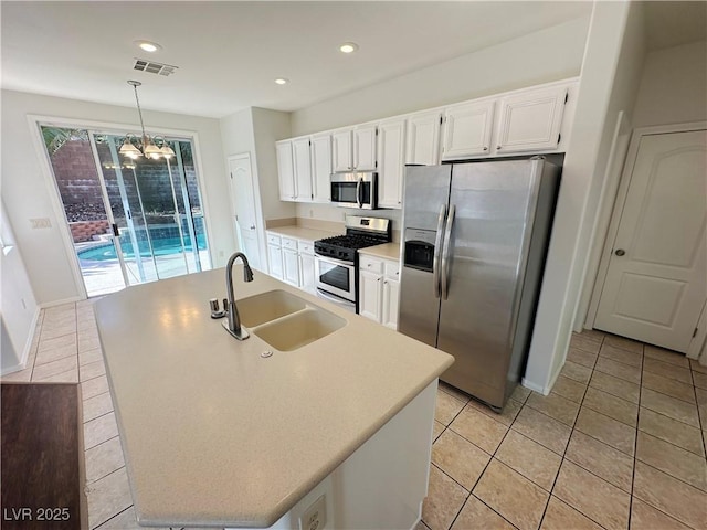 kitchen with a sink, light tile patterned flooring, appliances with stainless steel finishes, white cabinetry, and visible vents