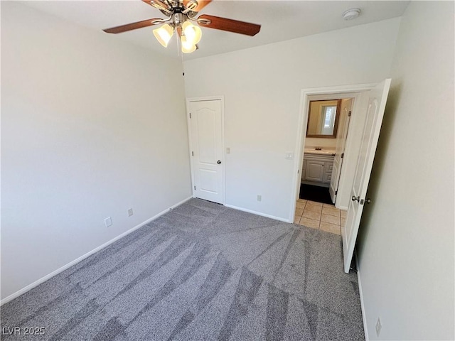 unfurnished bedroom with carpet floors, tile patterned flooring, baseboards, and a ceiling fan
