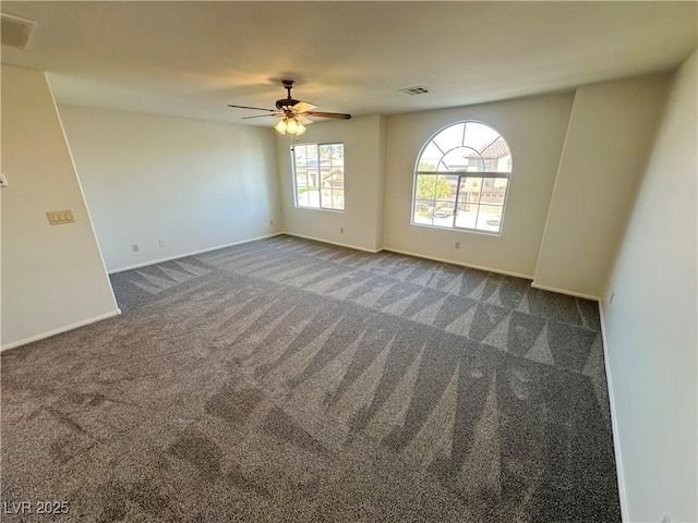 spare room with baseboards, a ceiling fan, visible vents, and carpet