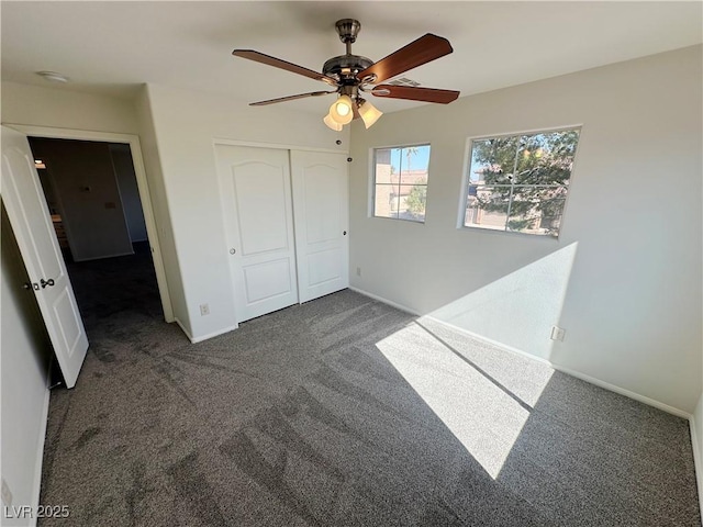 unfurnished bedroom with carpet floors, a closet, baseboards, and ceiling fan