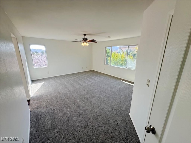 carpeted empty room with visible vents, a ceiling fan, and baseboards