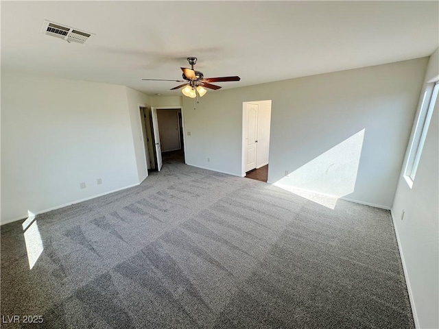 carpeted empty room featuring visible vents, baseboards, and ceiling fan