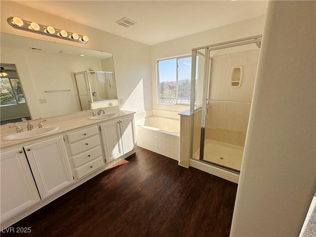 full bathroom with wood finished floors, a sink, visible vents, and a stall shower
