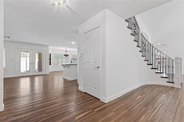 283 Grand Olympia Dr, Henderson, NV 89012 - entryway featuring dark wood-type flooring, stairway, french doors, baseboards, and a chandelier
