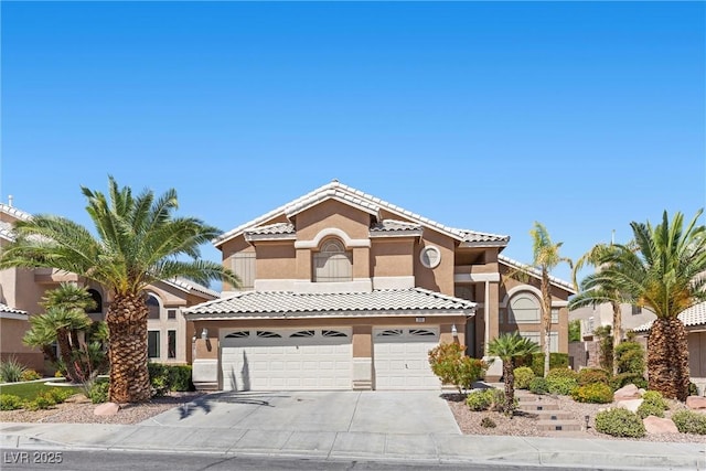 283 Grand Olympia Dr, Henderson, NV 89012 - mediterranean / spanish-style house featuring stucco siding, driveway, an attached garage, and a tile roof