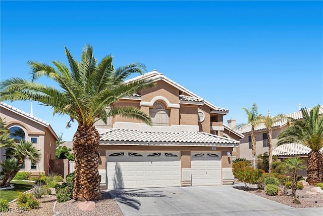 283 Grand Olympia Dr, Henderson, NV 89012 - mediterranean / spanish-style home featuring concrete driveway, stucco siding, a garage, and a tile roof