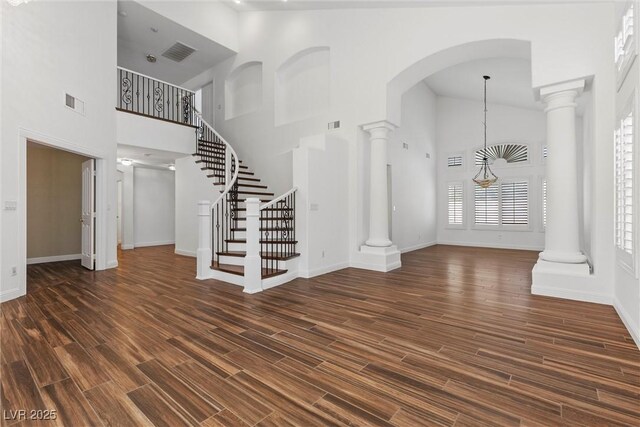 283 Grand Olympia Dr, Henderson, NV 89012 - entryway featuring a towering ceiling, decorative columns, stairway, baseboards, and dark wood finished floors