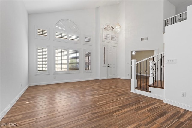 283 Grand Olympia Dr, Henderson, NV 89012 - entrance foyer featuring a chandelier, wood finished floors, a high ceiling, baseboards, and stairs